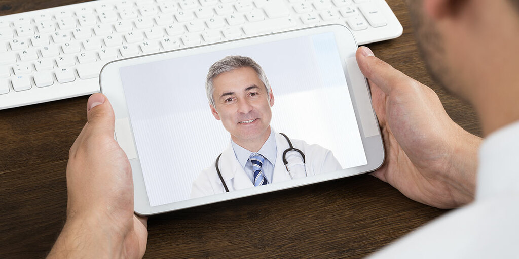 Tablet showing a doctor in a video call – symbolic image for MD Medicus 24/7 video consultation