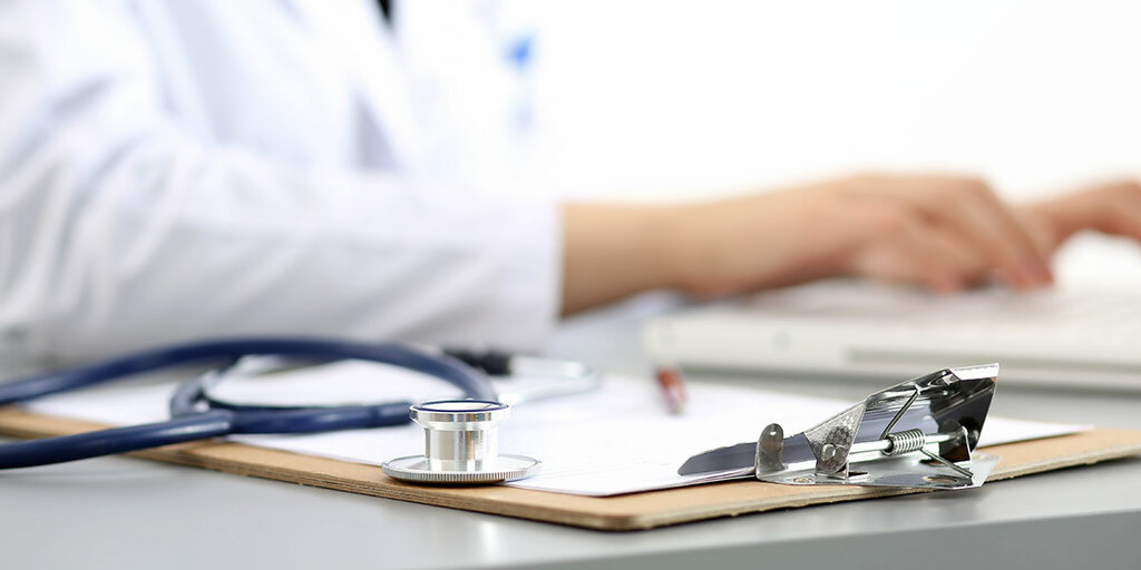 Stethoscope and documents on a desk – symbolic image for the MD Medicus TPA portal and claims processing