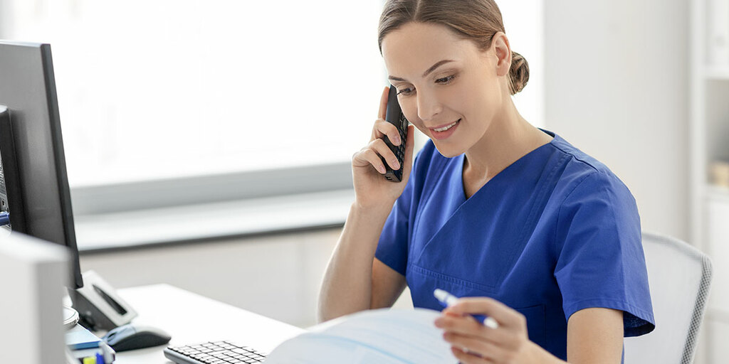 Care professional on the phone – symbolic image for support and services for care facilities