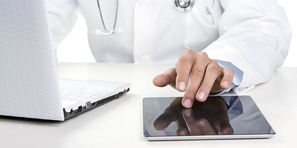 Ärztliche Nutzung von Tablet und Laptop – Symbolbild für die digitale Patientenakte von MD Medicus