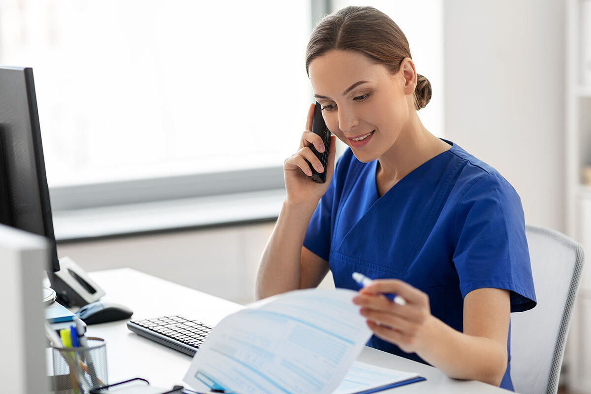 Pflegefachkraft telefoniert am Schreibtisch – Symbolbild für MD Medicus Pflege- und Reha-Management